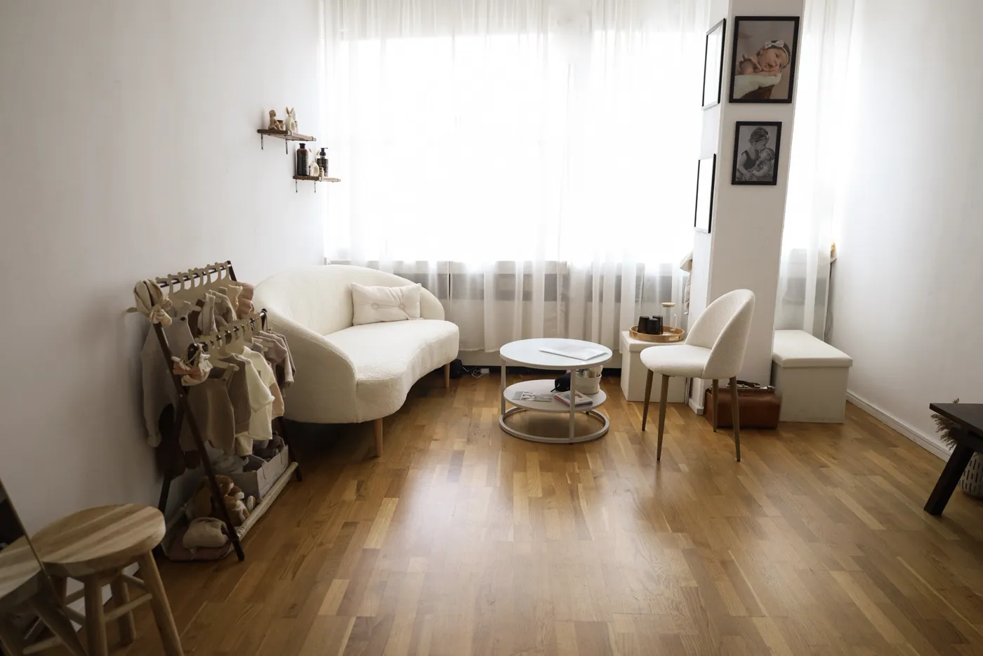 Fotostudio in Sindelfingen mit weißem Sofa, Kleiderständer mit Babyoutfits und hellen Vorhängen