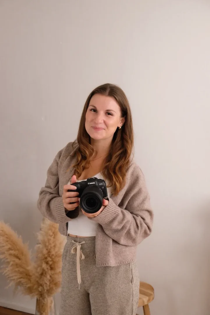 Lucia Farinaccio, Fotografin und Hebamme, steht lächelnd mit ihrer Kamera im Studio